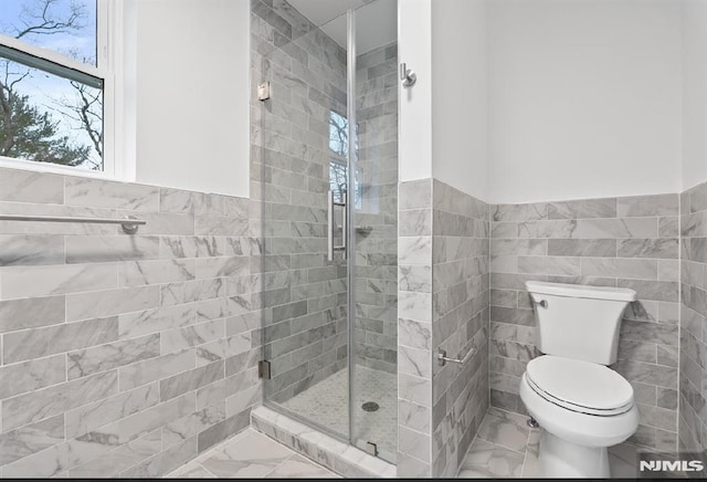 bathroom featuring toilet, walk in shower, and tile walls