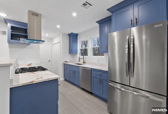 kitchen featuring appliances with stainless steel finishes, light stone counters, wall chimney exhaust hood, and sink