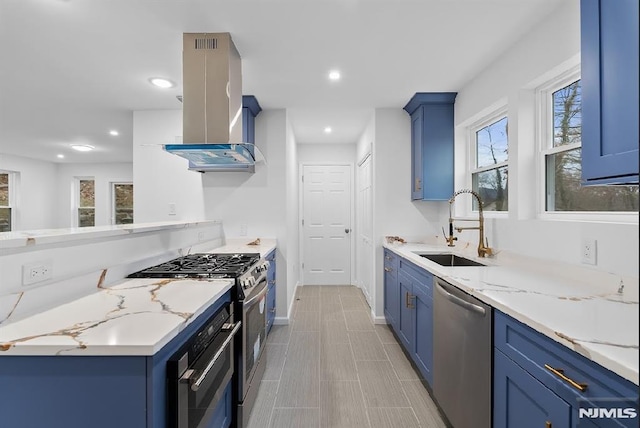 kitchen with light stone countertops, sink, wall chimney range hood, and stainless steel appliances