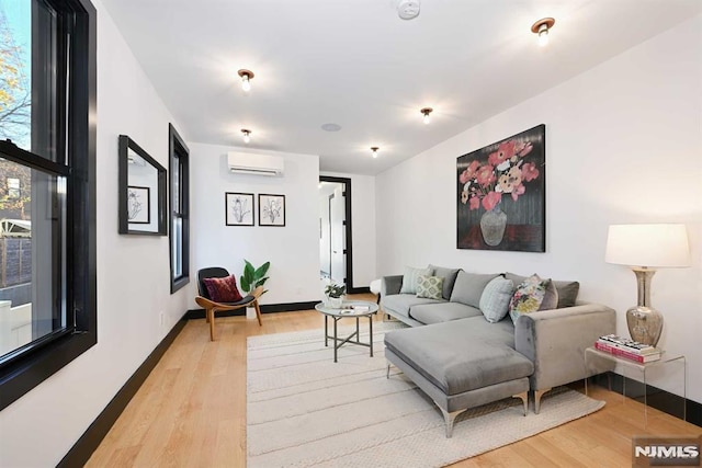 living room with a wall mounted air conditioner and hardwood / wood-style floors