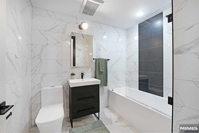 full bathroom with vanity, tub / shower combination, toilet, and tile walls