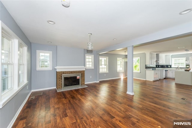 unfurnished living room featuring a fireplace and dark wood-type flooring