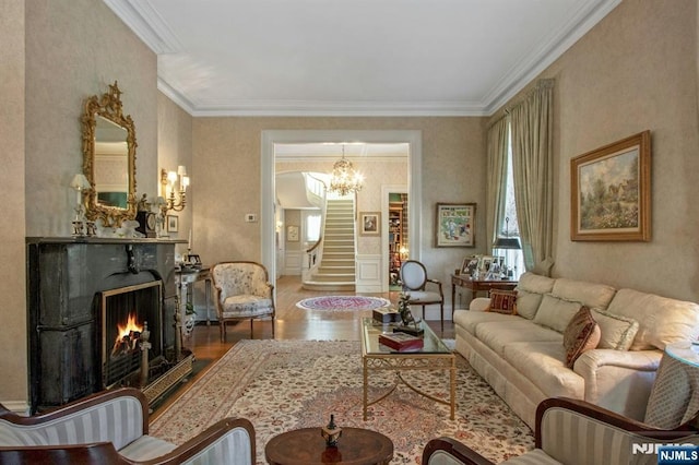 living area featuring a chandelier, wood finished floors, ornamental molding, and stairs