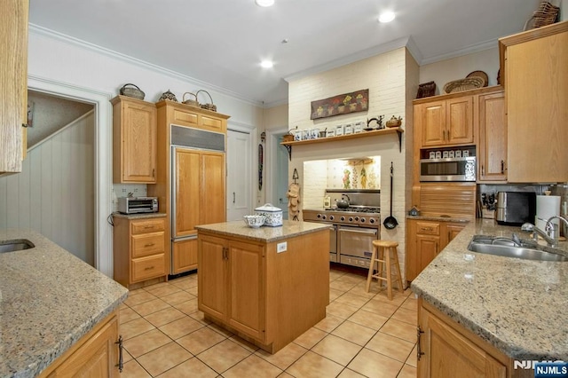 kitchen with a center island, light tile patterned floors, a sink, crown molding, and high quality appliances