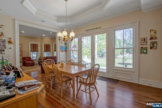 dining area with dark wood finished floors, crown molding, and plenty of natural light