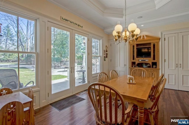 dining area featuring a healthy amount of sunlight, an inviting chandelier, and dark wood finished floors