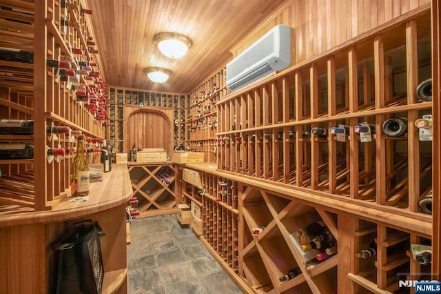 wine area with stone finish flooring, wood ceiling, and an AC wall unit