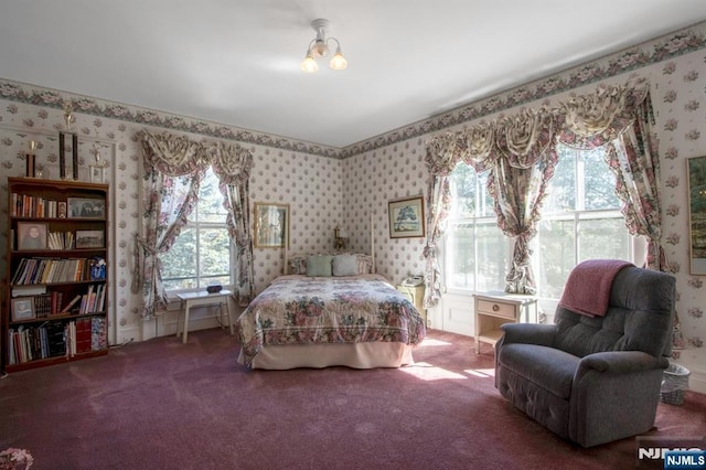 bedroom with multiple windows, wallpapered walls, and carpet