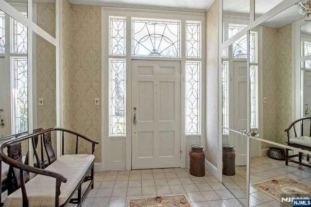 foyer with baseboards, light tile patterned floors, and wallpapered walls