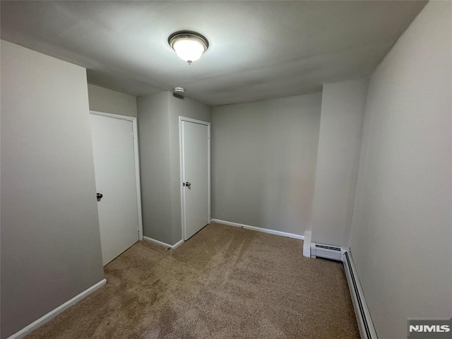 empty room featuring carpet and baseboard heating