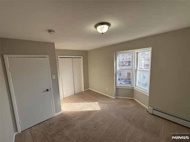 carpeted spare room with a baseboard radiator