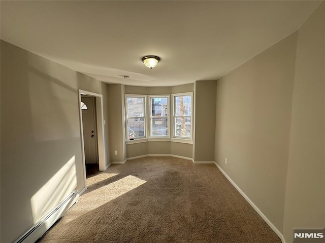 unfurnished room featuring carpet and a baseboard heating unit