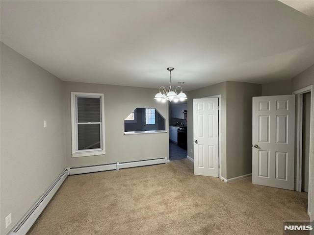 spare room featuring an inviting chandelier, light colored carpet, and a baseboard radiator