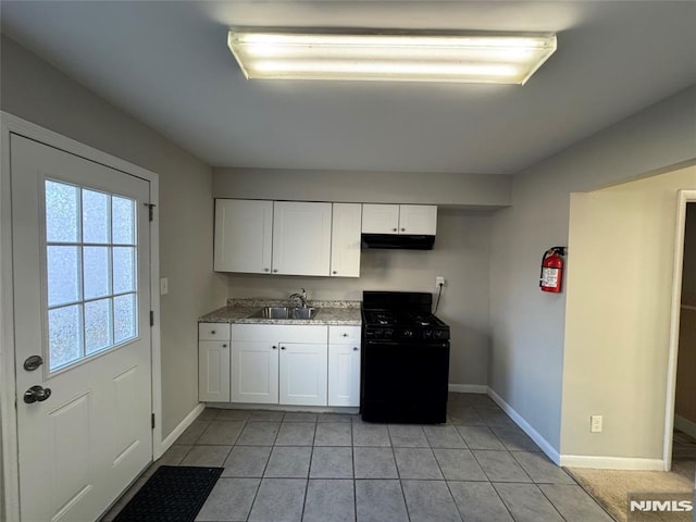 kitchen with black range with gas stovetop, sink, white cabinets, and light tile patterned floors