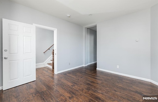 unfurnished room with dark hardwood / wood-style flooring