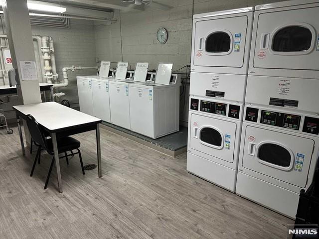 clothes washing area featuring separate washer and dryer, stacked washer and dryer, and light hardwood / wood-style floors