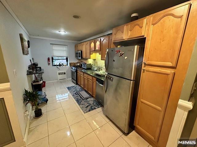 kitchen with stainless steel appliances, ornamental molding, and light tile patterned flooring