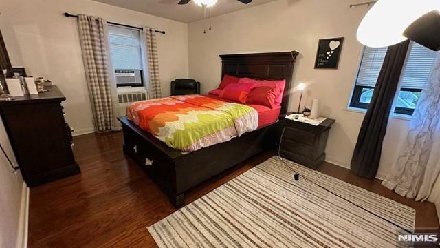 bedroom featuring dark hardwood / wood-style floors, ceiling fan, and cooling unit