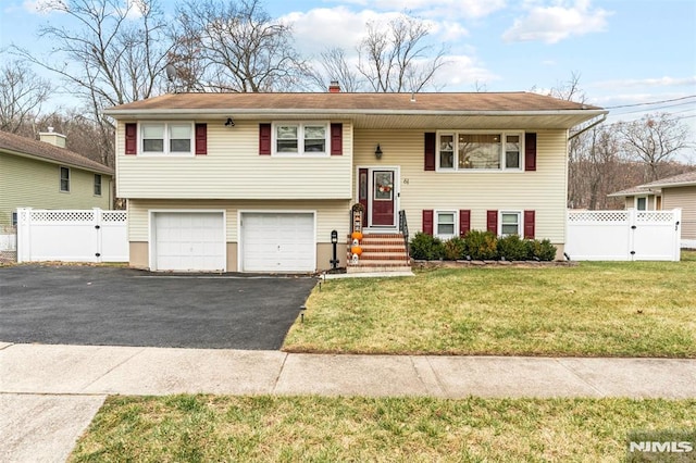 raised ranch with a front lawn and a garage