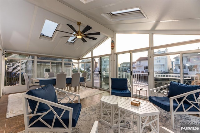 sunroom / solarium featuring lofted ceiling with skylight and ceiling fan