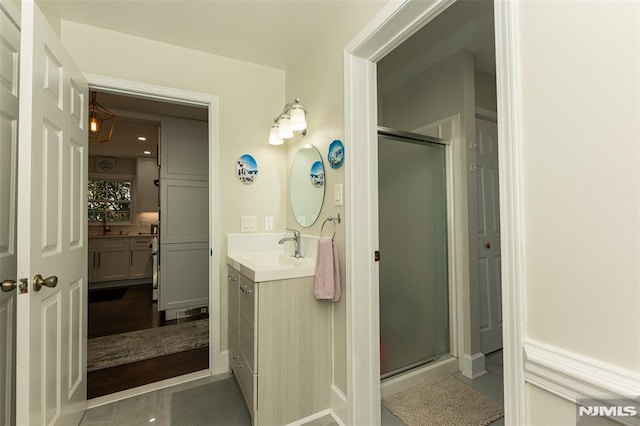 bathroom with tile patterned flooring, vanity, and a shower with shower door