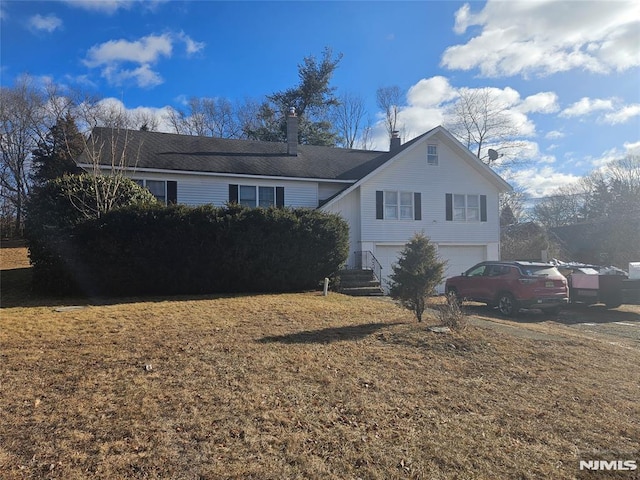 view of front of property with a front yard and a garage