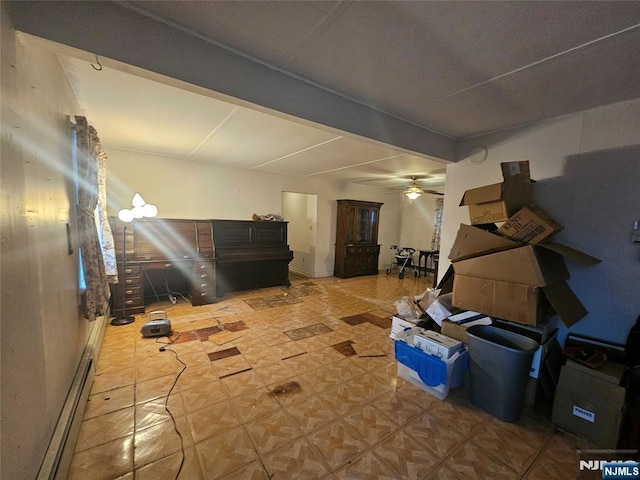 basement featuring ceiling fan and a baseboard radiator