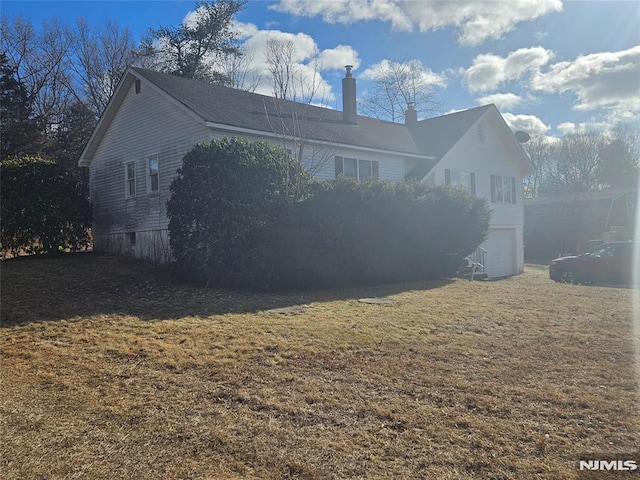 view of property exterior featuring a garage and a lawn