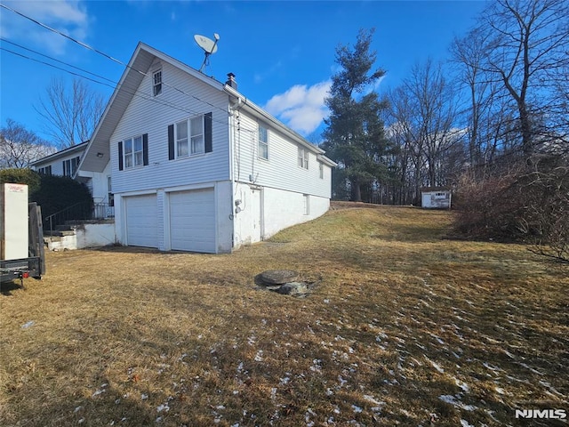 view of property exterior featuring a garage and a yard