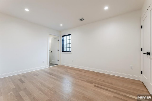 empty room with light hardwood / wood-style flooring