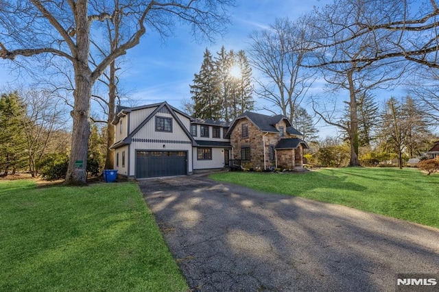 tudor house featuring a garage and a front yard