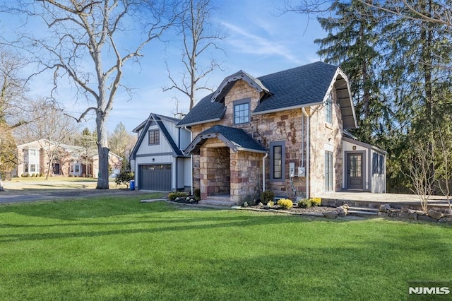 tudor home with a garage and a front lawn