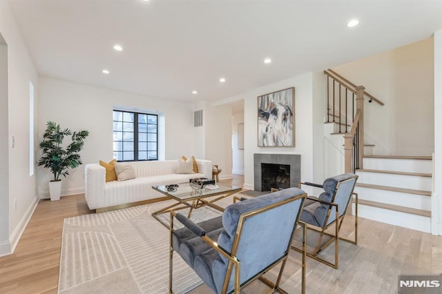 living room featuring light hardwood / wood-style floors and a tile fireplace