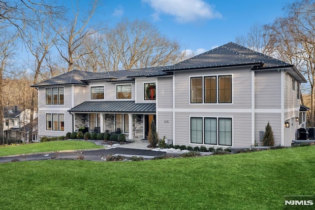 view of front of property with a porch, a garage, and a front lawn