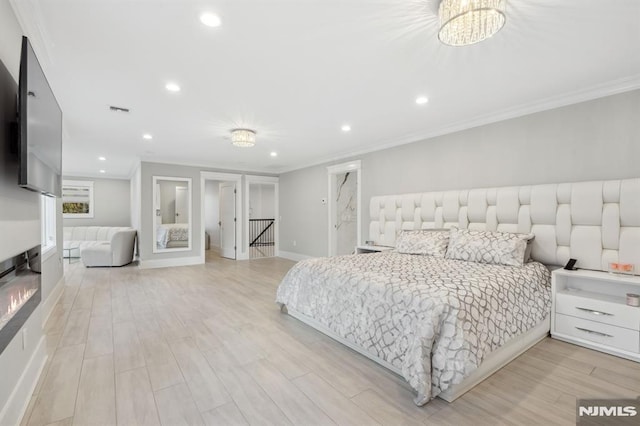 bedroom with light hardwood / wood-style floors, crown molding, and an inviting chandelier