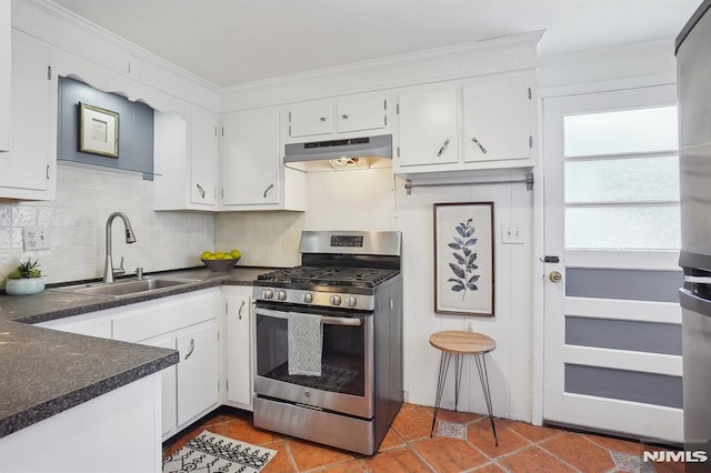 kitchen with white cabinets, stainless steel gas range, backsplash, and sink