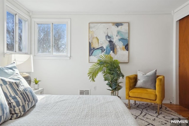 bedroom with crown molding and hardwood / wood-style floors