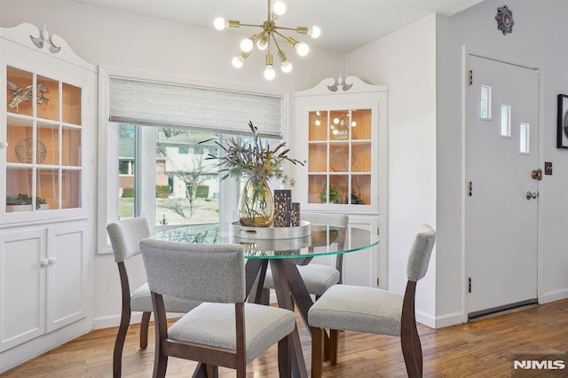 dining area with an inviting chandelier and light hardwood / wood-style flooring