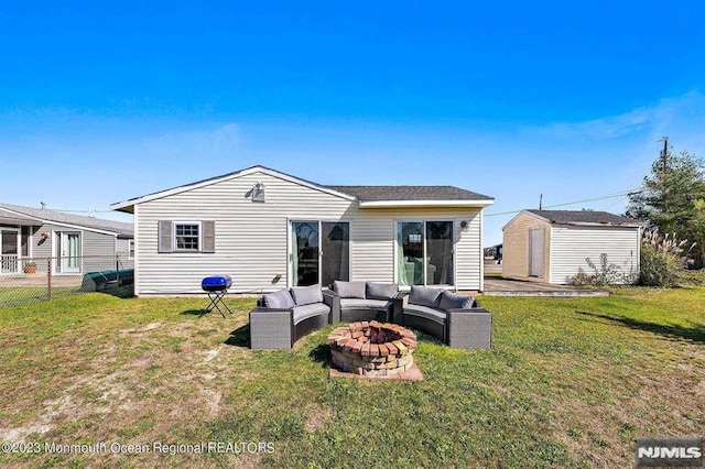 back of house featuring a yard, a storage unit, and an outdoor living space with a fire pit