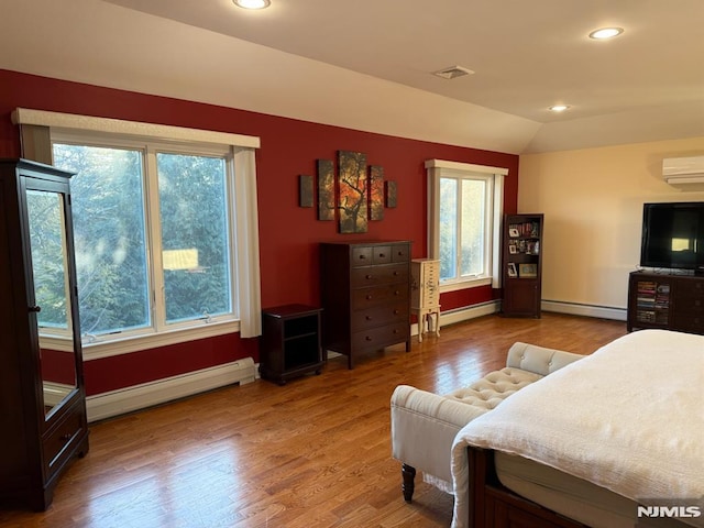 interior space with baseboard heating, wood-type flooring, plenty of natural light, and vaulted ceiling