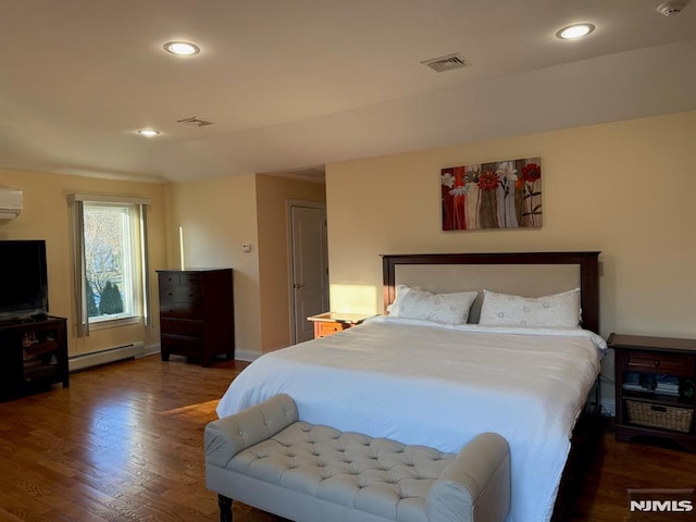 bedroom with an AC wall unit, dark wood-type flooring, and a baseboard heating unit