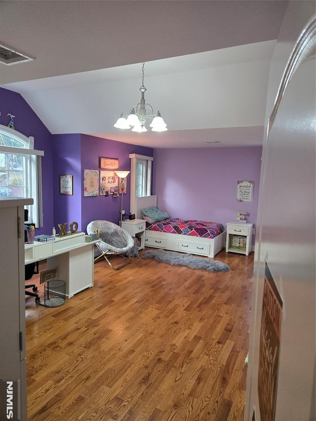 bedroom with wood-type flooring, a chandelier, and vaulted ceiling