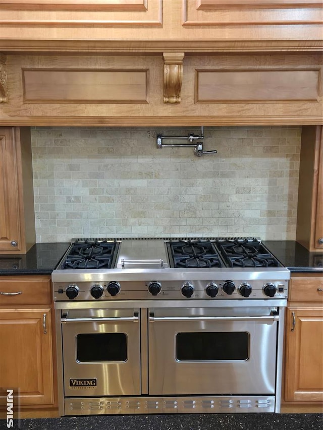 kitchen featuring double oven range, dark stone countertops, and tasteful backsplash