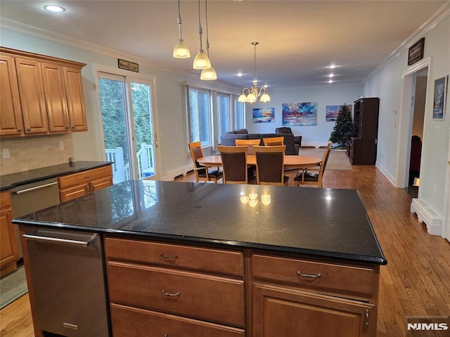 kitchen with backsplash, a center island, ornamental molding, and light wood-type flooring