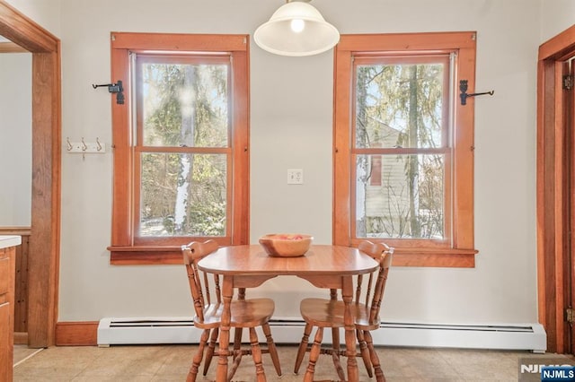 tiled dining area featuring a baseboard heating unit