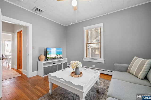 living room featuring ceiling fan, a baseboard radiator, ornamental molding, and hardwood / wood-style floors