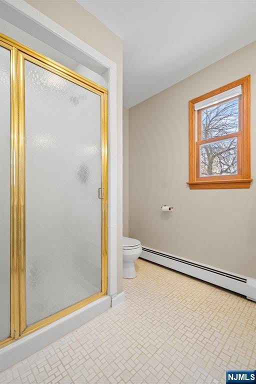 bathroom featuring toilet, an enclosed shower, and a baseboard heating unit