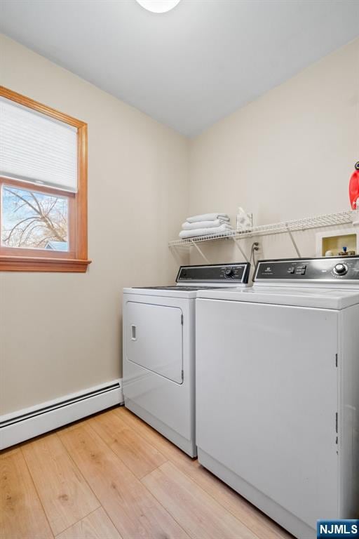 laundry area with independent washer and dryer, a baseboard radiator, and light hardwood / wood-style floors