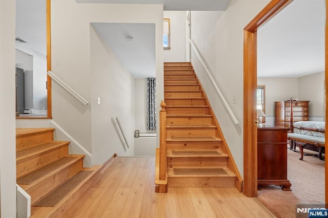 staircase with hardwood / wood-style floors