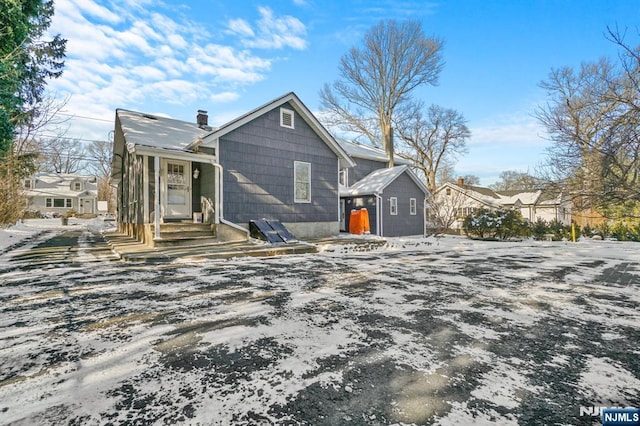 view of snow covered back of property